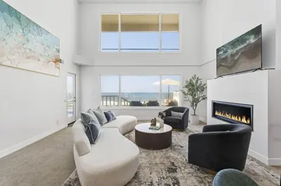 a living room with a couch and a fireplace at Sea Glass Beach Road Villa On the SAND Luxury and relaxation in Dana Point