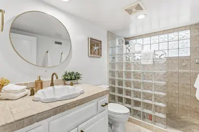 a bathroom with a sink and a mirror at Sea Glass Beach Road Villa On the SAND Luxury and relaxation in Dana Point