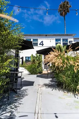 a patio with tables and chairs and a building at Simple La Jolla Epic bungalow # 3 in San Diego
