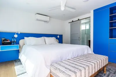 a blue bedroom with a white bed and a blue wall at Simple La Jolla Epic bungalow #7 in San Diego
