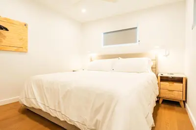 a bedroom with a white bed and a night stand at Simple La Jolla 2 bedroom - Alley Unit in San Diego
