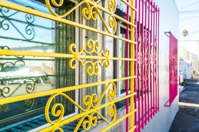 a yellow metal gate on a building with a street at Simple La Jolla 2 bedroom - Alley Unit in San Diego
