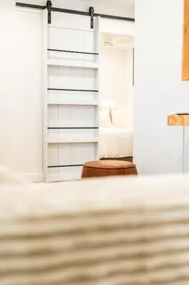 a room with a bed and a wooden stool at Simple La Jolla 2 bedroom - Alley Unit in San Diego