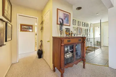 a living room with a fireplace and a cat sitting in the hallway at A Visit to Grandma's House in San Diego