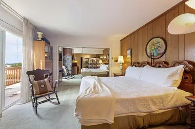 a bedroom with a bed and a chair and a balcony at Stay at Grandmas Entire Home with Yard & Balcony in San Diego