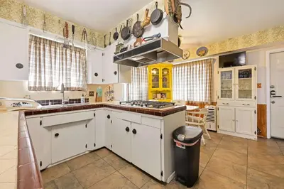 a kitchen with white cabinets and a stove top oven at Stay at Grandmas Entire Home with Yard & Balcony in San Diego
