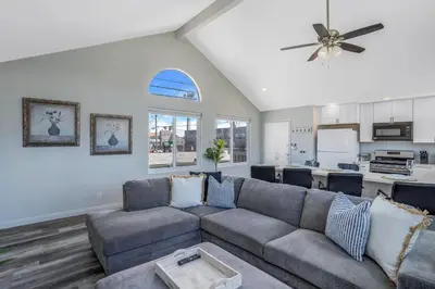 a living room with a couch and a kitchen at Walk to Ocean Beach Stylish 2BR Apt with Patio in San Diego
