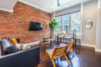 a living room with a couch and a brick wall at Gaslamp 2BR Upscale Queen Beds with Smart TV in San Diego