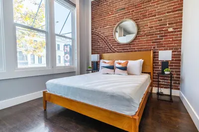 a bed in a room with a brick wall at Gaslamp 2BR Upscale Queen Beds with Smart TV in San Diego