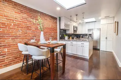 a kitchen with a brick wall and a table and chairs at Family-Friendly Apartment with Kitchen in San Diego