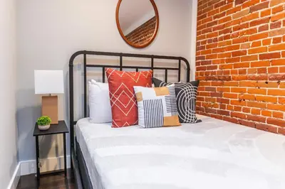 a bedroom with a brick wall and a bed with pillows at Family-Friendly Apartment with Kitchen in San Diego