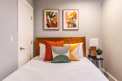 a bedroom with a bed with orange and white pillows at Family-Friendly Apartment with Kitchen in San Diego