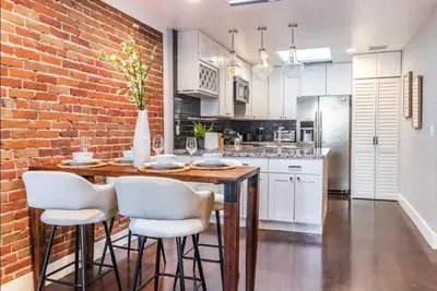 a kitchen with a brick wall and a table and chairs at Family-Friendly Apartment with Kitchen in San Diego