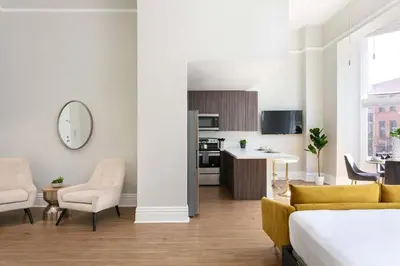 a living room with a bed and a kitchen at Gaslamp Loft Escape Sleeps 7 in Style in San Diego
