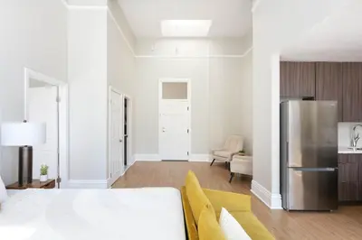 a white room with a bed and a refrigerator at Gaslamp Loft Escape Sleeps 7 in Style in San Diego