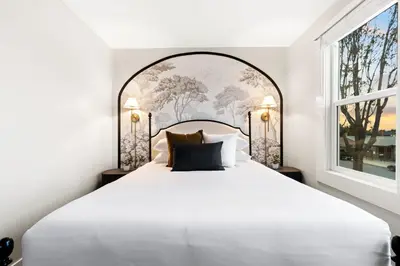 a bedroom with a large white bed with a large window at Updated Historic Suite with Queen Bed and Kitchen in San Diego