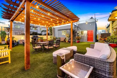 a patio with a wooden pergola and a table and chairs at Historic Apartment with Roof Deck in the Heart of North Park in San Diego