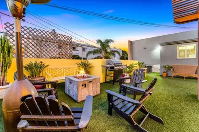 a backyard with chairs and a grill and a table at Historic Apartment with Roof Deck in the Heart of North Park in San Diego