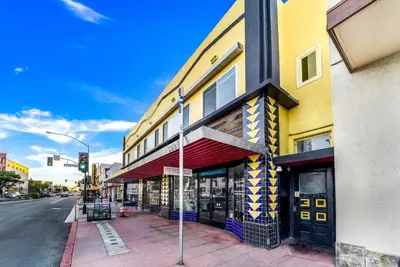 a building on the corner of a street with a traffic light at Historic Apartment with Roof Deck in the Heart of North Park in San Diego