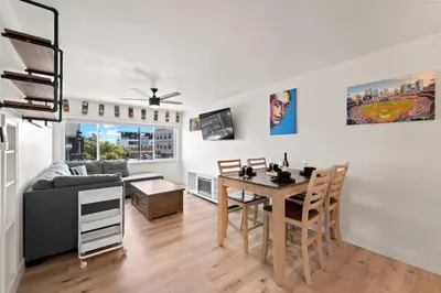a living room with a table and a couch at Historic Apartment with Roof Deck in the Heart of North Park in San Diego