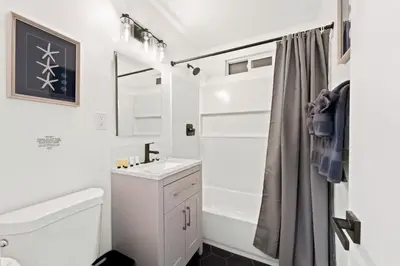 a white bathroom with a sink and a shower at Spacious Group Getaway Games BBQ with Free Parking in San Diego