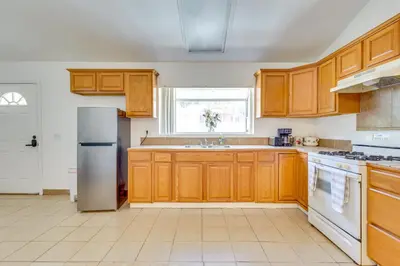 a kitchen with wooden cabinets and a white refrigerator at 4 Mi to Lake Elsinore Pet-Friendly Adventure Base in Lake Elsinore