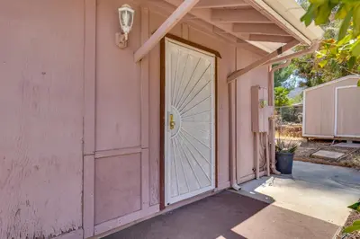 a pink house with a large white door at 4 Mi to Lake Elsinore Pet-Friendly Adventure Base in Lake Elsinore