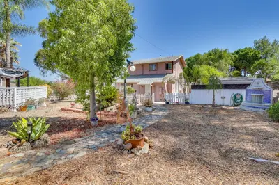a house with a tree and a fence at 4 Mi to Lake Elsinore Pet-Friendly Adventure Base in Lake Elsinore