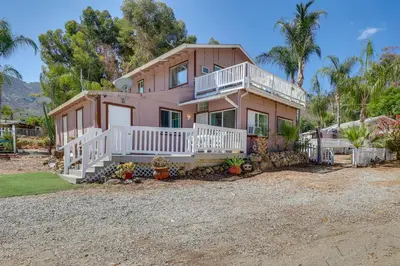 a pink house with a porch and white railings at Lake Elsinore Apt 4 Mi to Water Pets Welcome! in Lake Elsinore