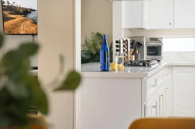 a kitchen with white cabinets and a stove top oven at Near Safari & Beach - Backyard Games - AC - Pet OK in Escondido