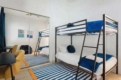 a bedroom with two bunk beds and a mirror at Near Safari & Beach - Backyard Games - AC - Pet OK in Escondido