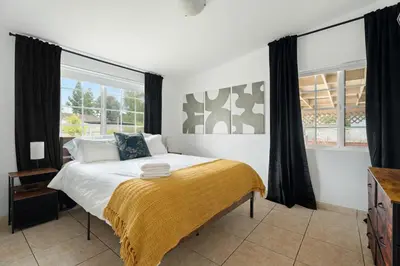 a bedroom with a bed and a large window at Near Safari & Beach - Backyard Games - AC - Pet OK in Escondido