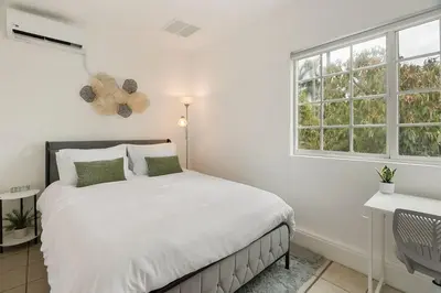 a white bedroom with a bed and a window at Casita Full Kitchen-AC-Ping Pong in Escondido