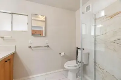 a bathroom with a toilet and a glass shower at Casita Full Kitchen-AC-Ping Pong in Escondido