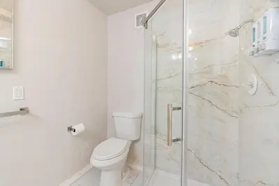 a bathroom with a toilet and a glass shower at Casita Full Kitchen-AC-Ping Pong in Escondido