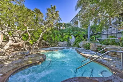 a hot tub in a garden with a tree at Steps to Shore Condo with Resort Perks in Oceanside in Oceanside