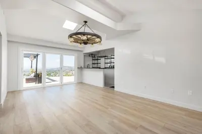 an empty living room with a large window and a chandelier at Hilltop Getaway with Sunset Views in Temecula