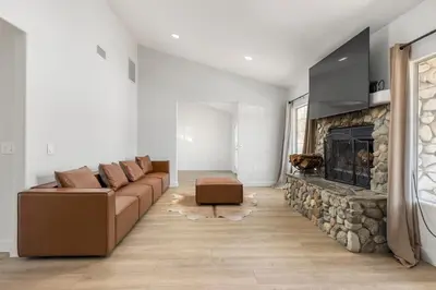 a living room with a couch and a stone fireplace at Hilltop Getaway with Sunset Views in Temecula