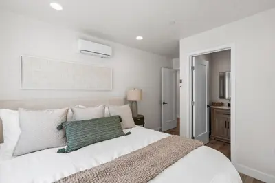 a bedroom with a white bed with a green pillow at Modern Organic Getaway - New 2 Bed 2 Bath - Close to Beaches & Downtown in San Diego