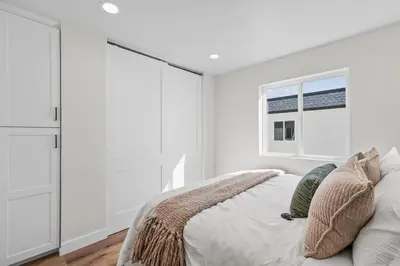 a bedroom with white walls and a bed with pillows at Modern Organic Getaway - New 2 Bed 2 Bath - Close to Beaches & Downtown in San Diego