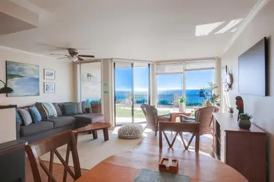a living room with a couch and a table and chairs at Ocean 11 condo in Solana Beach