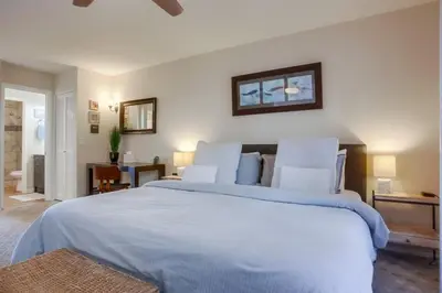 a bedroom with a large bed with white sheets at Ocean 11 condo in Solana Beach