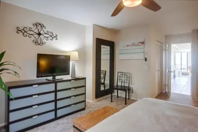 a bedroom with a dresser with a television on it at Ocean 11 condo in Solana Beach