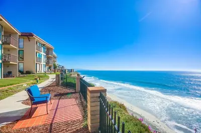 a blue chair sitting on a sidewalk next to the ocean at Ocean 11 condo in Solana Beach