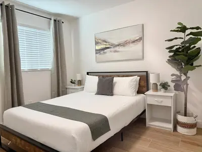 a bedroom with a bed and a potted plant at Designer's Touch in San Diego
