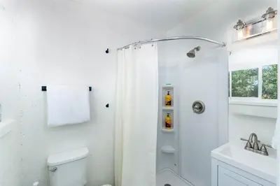 a white bathroom with a shower and a toilet at Comfy Bay Park Cottage close to Everything! in San Diego