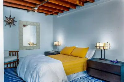 a bedroom with a bed with yellow sheets and two lamps at Comfy Bay Park Cottage close to Everything! in San Diego