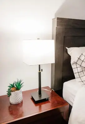 a lamp on a wooden table next to a bed at Mira Mesa Private Suite with Private Bath & Entry #2 in San Diego