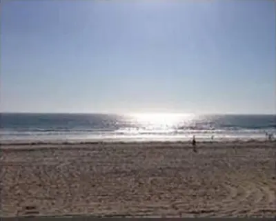 a person standing on a beach near the ocean at Ocean Front On Beach! -2 Master BR, 2 Full BA, Patio!, AC, Parking, Close to All in San Diego