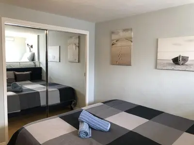 a bedroom with two beds and a mirror at Ocean Front Beauty right on Best Beach in Mission Beach, San Diego! in San Diego